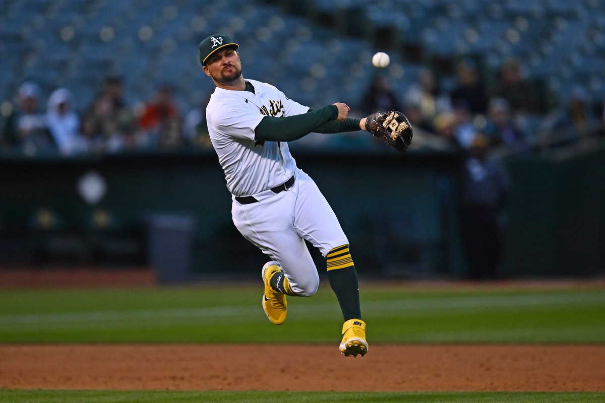 Oakland Athletics' J.D. Davis (5) attempts to throw out Washington Nationals' Lane Thomas (28) at first base in the third inning of their MLB game at the Coliseum in Oakland, Calif., on Friday, April 12, 2024. Thomas would be safe at first. #rootedinoakland