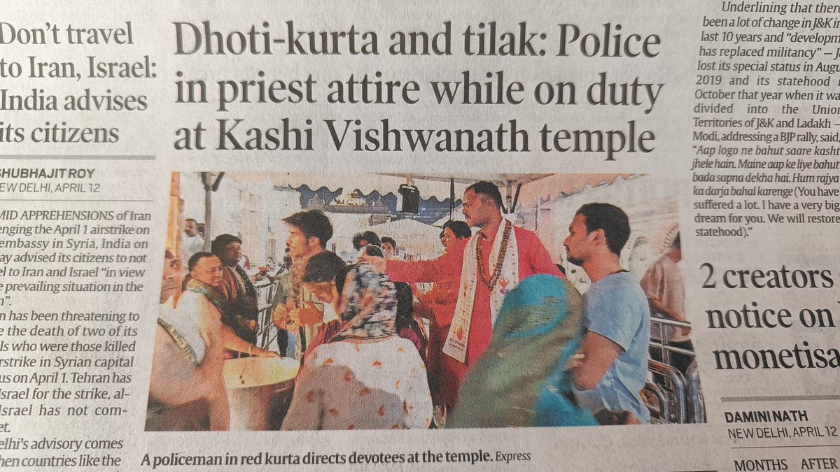 A policeman in red kurta directs devotees at the temple.