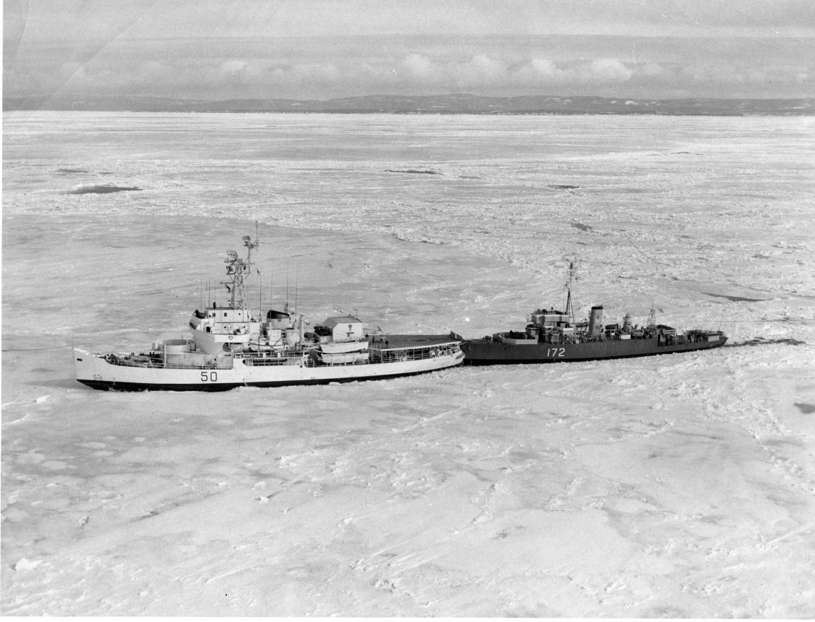 #OTD 13/4/1956 #RememeberRCN -HMCS LABRADOR takes HMCS WALLACEBURG into its towing notch and leads the frigate out of Pictou. WALLACEBURG had just completed a refit and was set in 10/10 ice pack in the harbour.