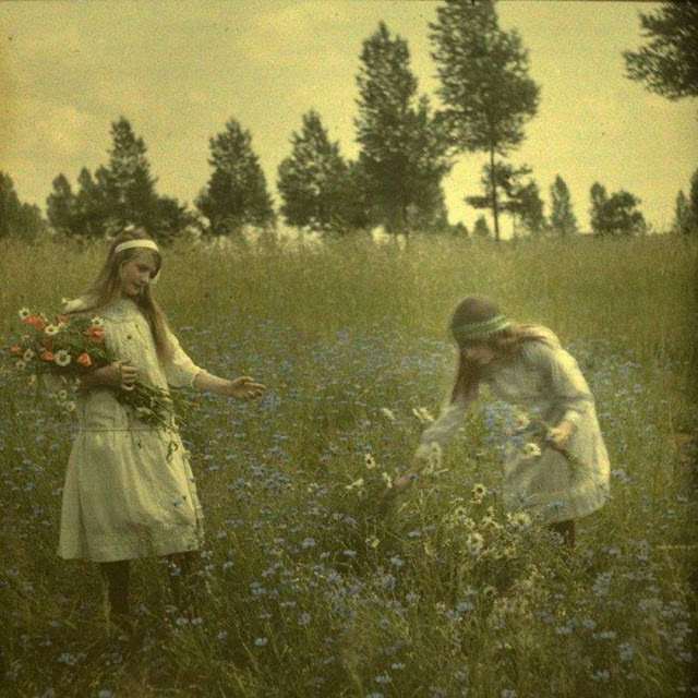 Autochrome picture of two girls picking flowers. Photographed in 1912.