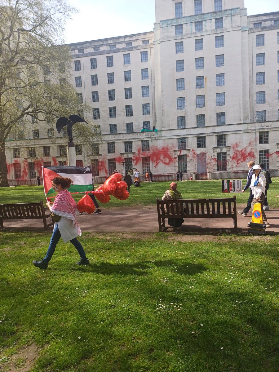 Perfect timing of this legend walking with her balloons #FreePalestine can you spot the 2 workers trying to cover the red paint?