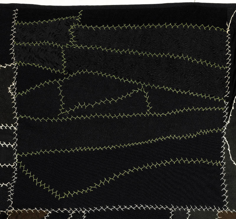 This quilt from 1922 is an interpretation of the 'Crazy quilt' pattern. Rather than displaying extravagant embroidery that was typical of nineteenth century Crazy quilts, this artwork is a subdued study in monochromatic shades of black and dark colors.