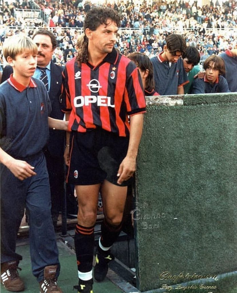 Roberto Baggio luciendo la camisa del Milan durante la temporada 1995/96. A que no adivinas quien es el niño que lo acompaña en la foto… se van a caer para atrás.
