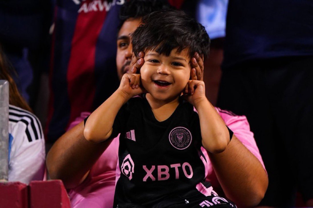 An adorable young fan experiencing the opportunity of a lifetime: witnessing Lionel Messi play live!