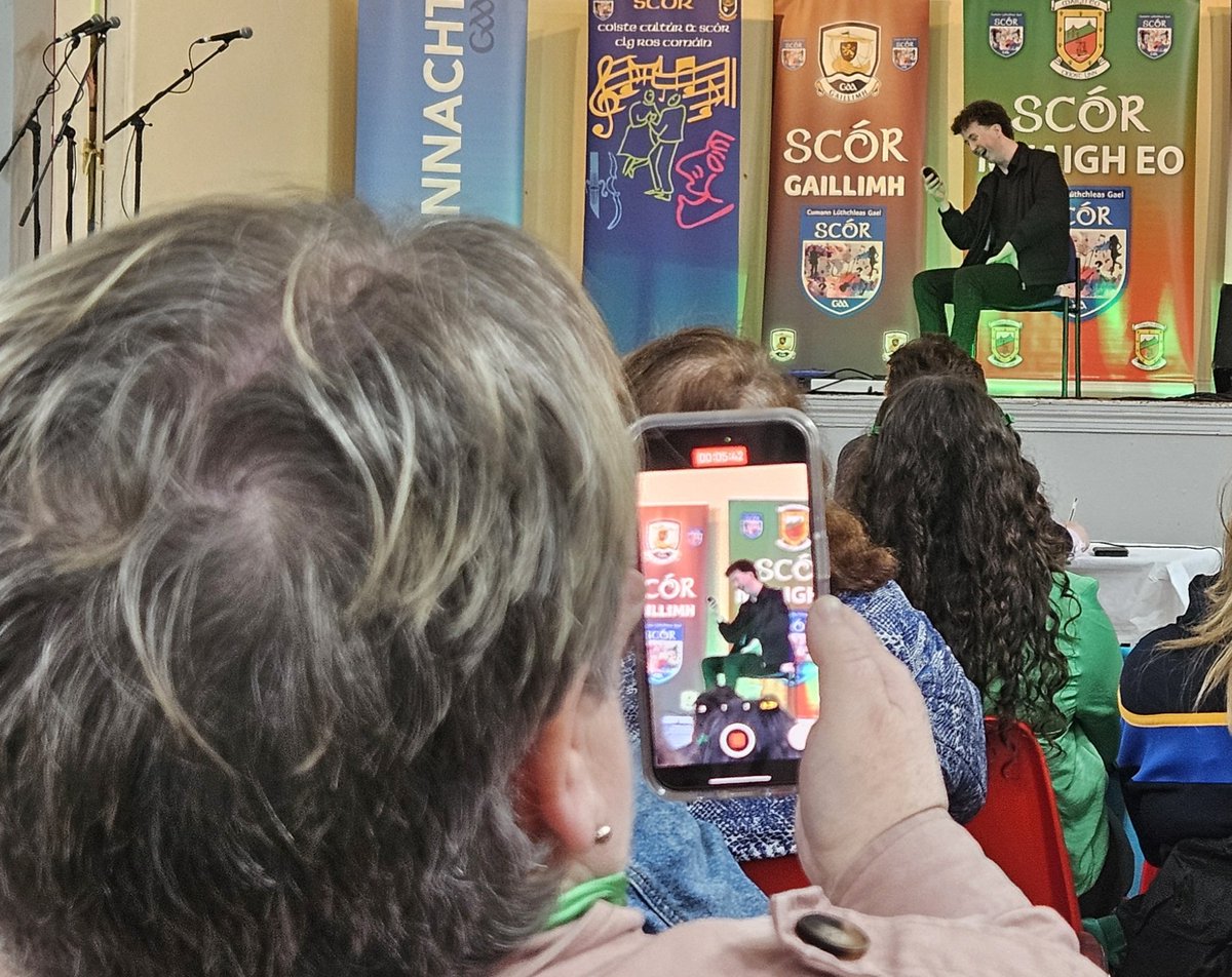 For The Record.... A fan recording the @clgacla competitor in the Scéalaíocht competition here in Tooreen at the #ConnachtScór Final. #GAABelong.