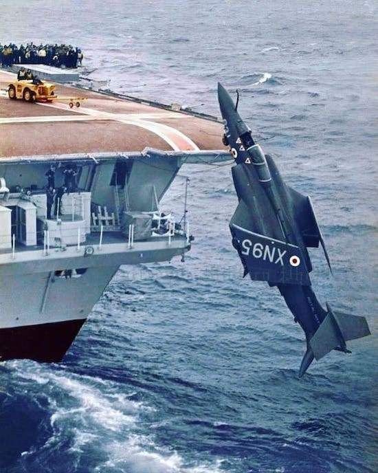 An R.A.F. Blackburn Buccaneer is deliberately dropped off the back of the HMS Ark Royal into the English Channel during the filming of a safety film.