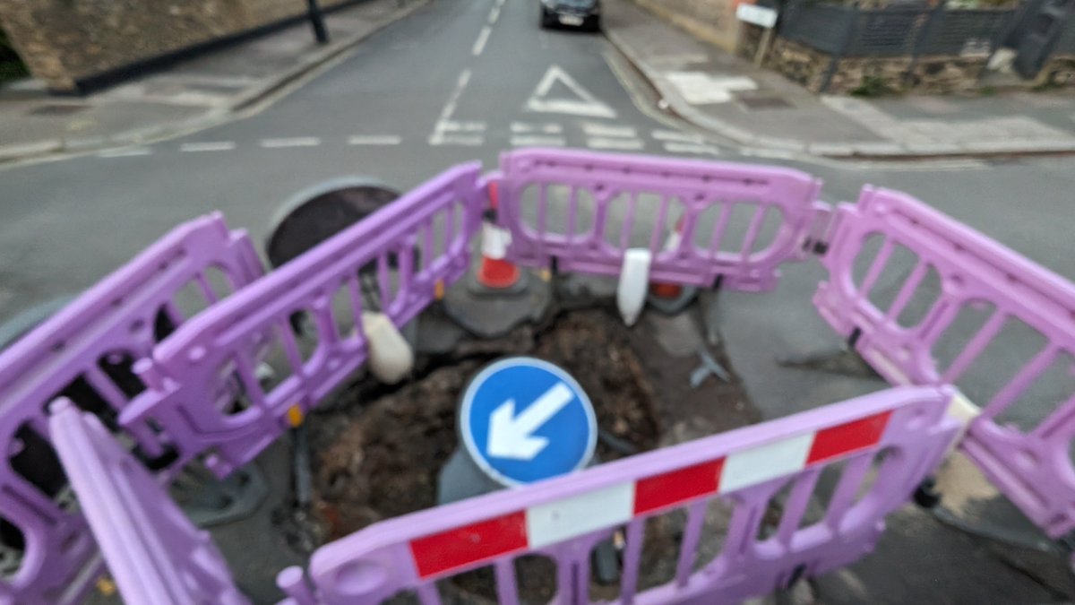 Live now to former LTN21: The latest is that the car has been moved a foot or so from the garden wall so that pedestrians can pass. Wheelchair users and those pushing pushchairs are advised to seek alternative routes. The Midhurst sink hole appears stable at around 2ft deep.