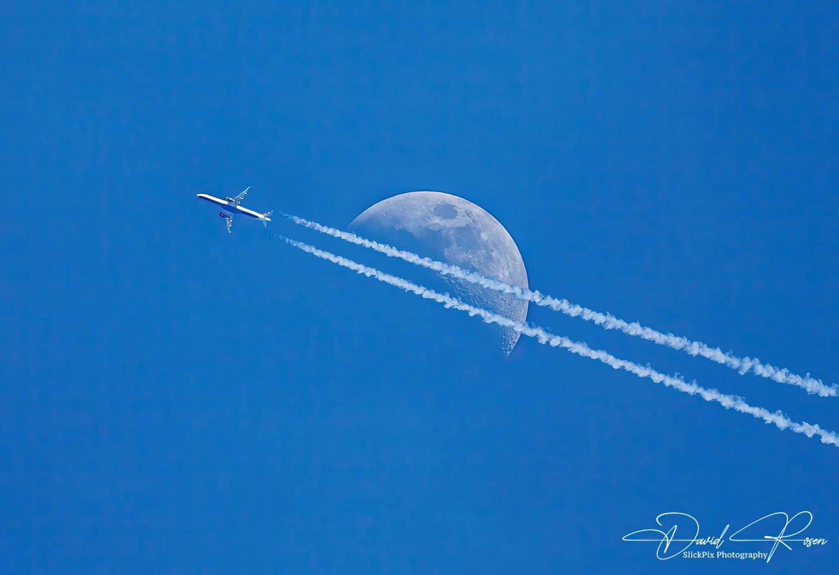 A plane with contrails passes in front of the waxing crescent moon (35.1%) during a beautiful sunny afternoon on 04/14/2024. Photo © 2024 David Rosen/SlickPix Photography