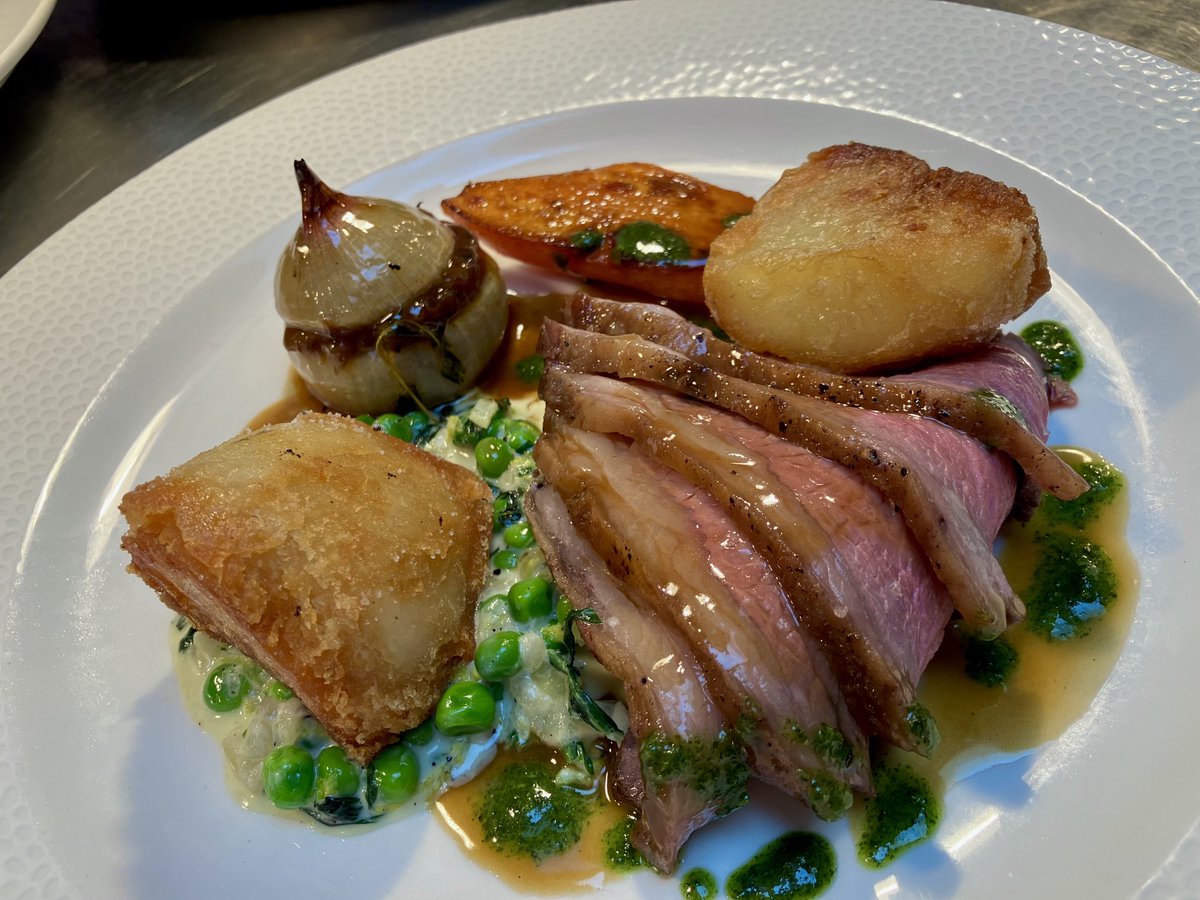 Roast rump of lamb, onion stuffed with shoulder, duck-fat roasties, mint sauce and peas