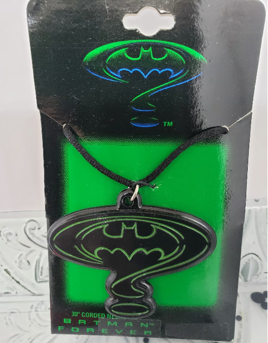 Photo of a Batman Forever 30' Cord Necklace, featuring the film's iconic logo as the necklace pendant/charm. Having the film's logo but in Black with just a green outline is a really cool look.