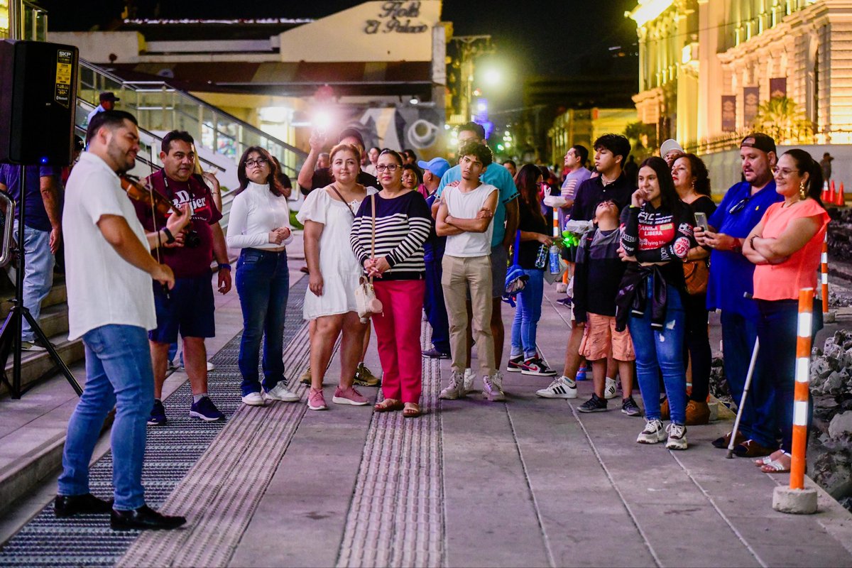 Los turistas se acercan frente a @BINAES para escuchar música con violín.