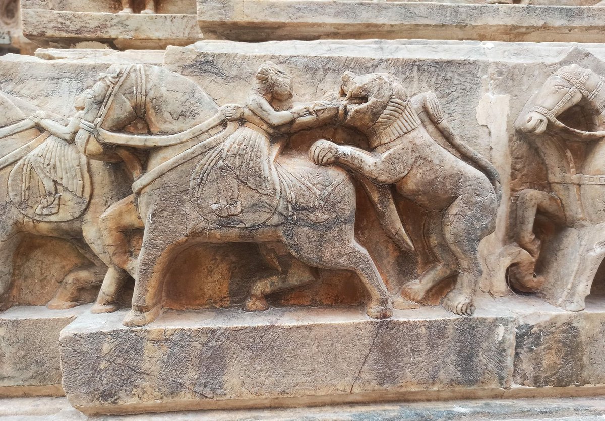 A warrior on horseback stabbing a charging lion with a dagger. Location: Jagdish Temple, Udaipur.