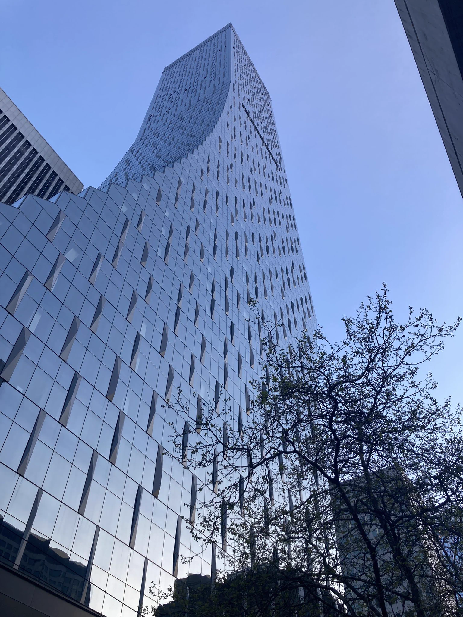 A large, glass building, the left side of it curved in an arc as it goes up