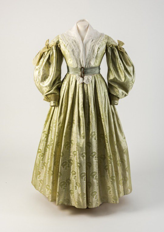 Spring greens flourish in mid #1830s fashion here, soft figured silk that is pleated and cinched by stitch and belt into modish folds typical of the period. The sleeve is a focus, its fullness ebbing and flowing as the decade progressed @Fashion_Museum #fashionhistory