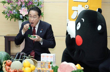 Kumamon watches Prime Minister Kishida (left) eat watermelon from Kumamoto.