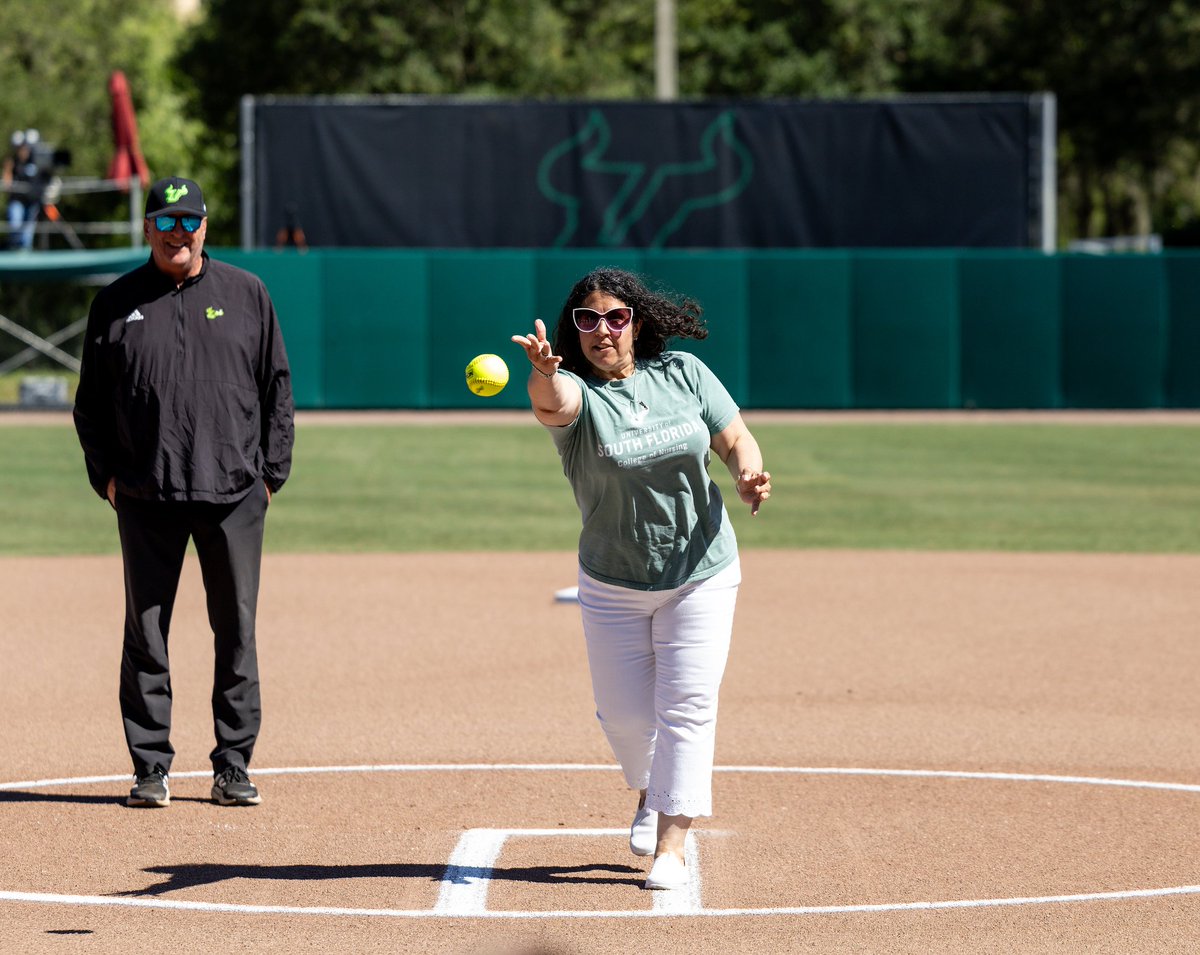 Dr. Ann Lyles is up to any challenge! Even those completely out of her comfort zone, like throwing out an excellent first pitch at a @USFSoftball game! 💚🤘🏽🥎