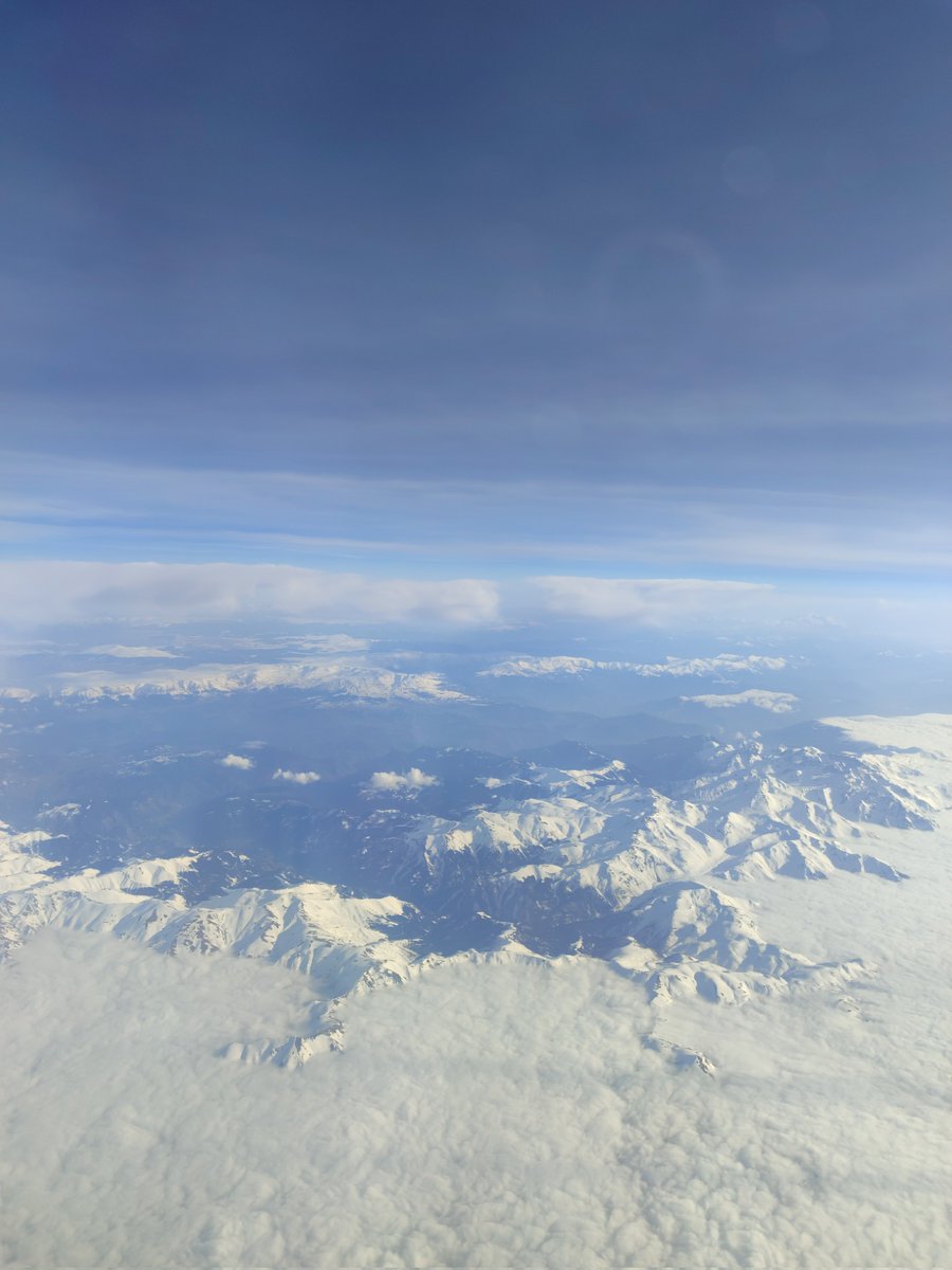 Clouds floating around the mountain peaks. 
Captured during the Istanbul-Baku flight. Since there was no screen showing the map on the plane, I could not guess which country it was flying over.