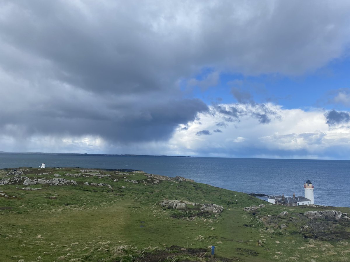 Moody rain showers sweeping along the Fife coast, viewed from the Isle of May