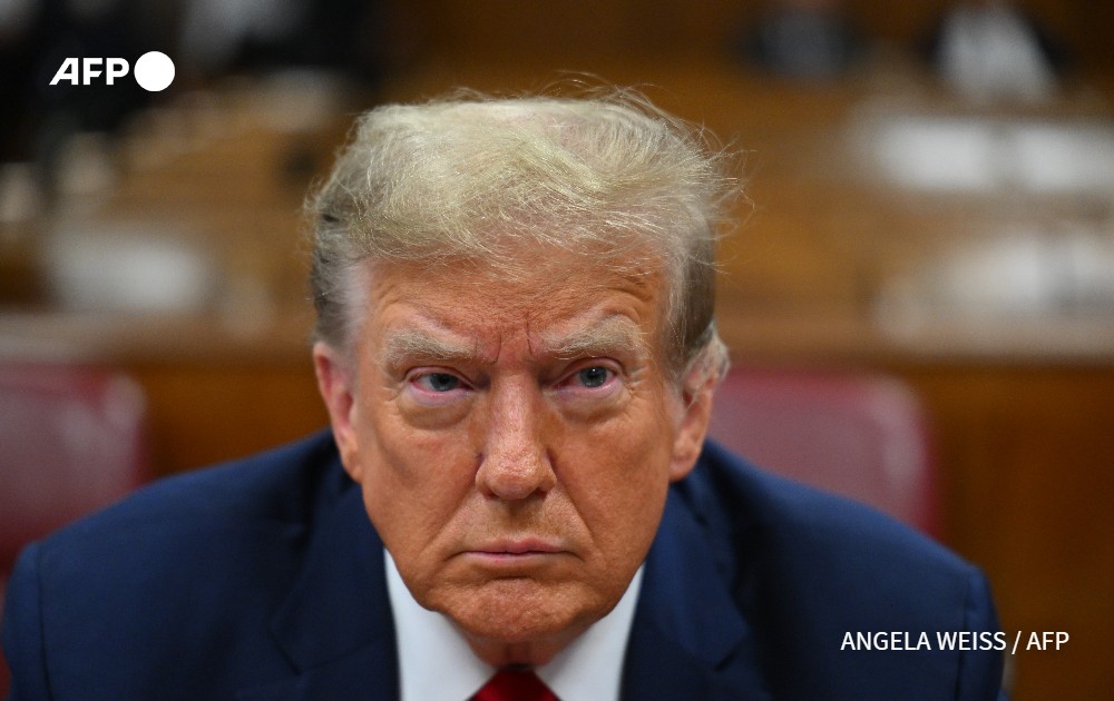 Comment décrire une telle expression faciale ? Visage fermé ? Traits tendus ? Extrême gravité ? Air de défi ? C'est en tout cas une photo #AFP déjà historique, celle du premier ex-président américain assis sur le banc des prévenus d'un procès pénal