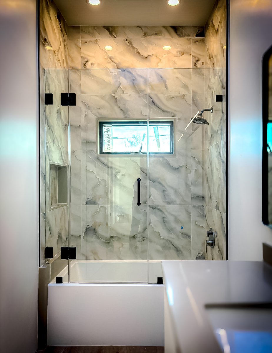 Immerse yourself in the tranquility of this beautifully installed shower enclosure by Affordable Frameless Shower Door Inc. The pristine clarity of the glass pairs with the sublime marble wall to create a serene retreat. #SereneShower #MinimalistDesign #MatteBlackDetailing