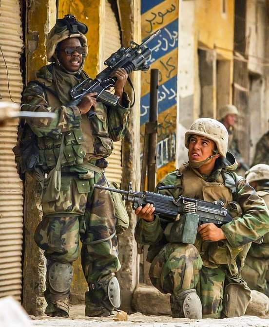 U.S. Marines with 3rd Battalion, 4th Marine Regiment are photographed on April 6, 2003, as they move up the street, on the outskirts of Baghdad to seize the east bridge that grants main access to the city.