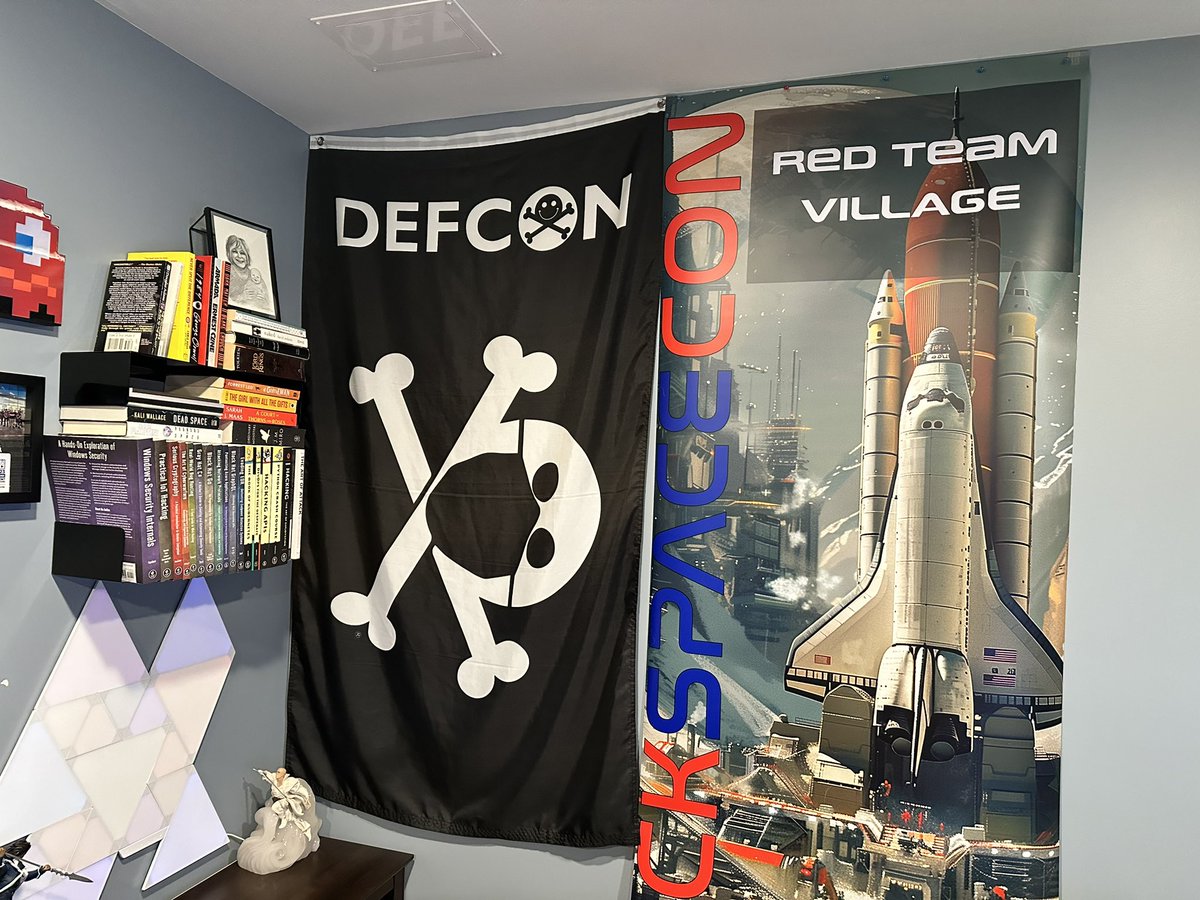 MikeHacksThings's tweet photo. In addition to the three badges I collected from #HackSpaceCon, I was also able to take home the @RedTeamVillage_ banner. Looks great on the wall if I do say so myself. #badgelife https://t.co/5lIpwsMHwU