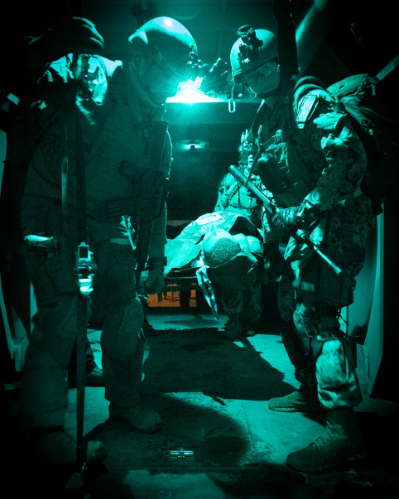 NIGHT OPS (training) - As darkness prevails, a dynamic duo from Navy Medicine loads a simulated patient as part of an ORE conducted by NMOTC at Camp Pendleton, CA. These remarkable individuals form an ECRS, a 2-person team that delivers medical care on the move.