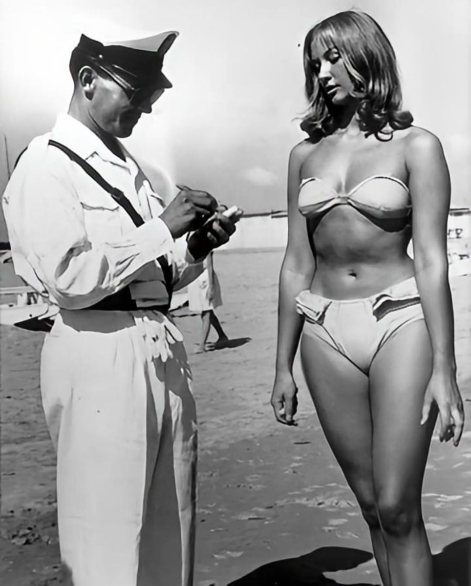 Mujer recibiendo multa por llevar bikini en una playa italiana, 1957 🇮🇹👱‍♀️👙.