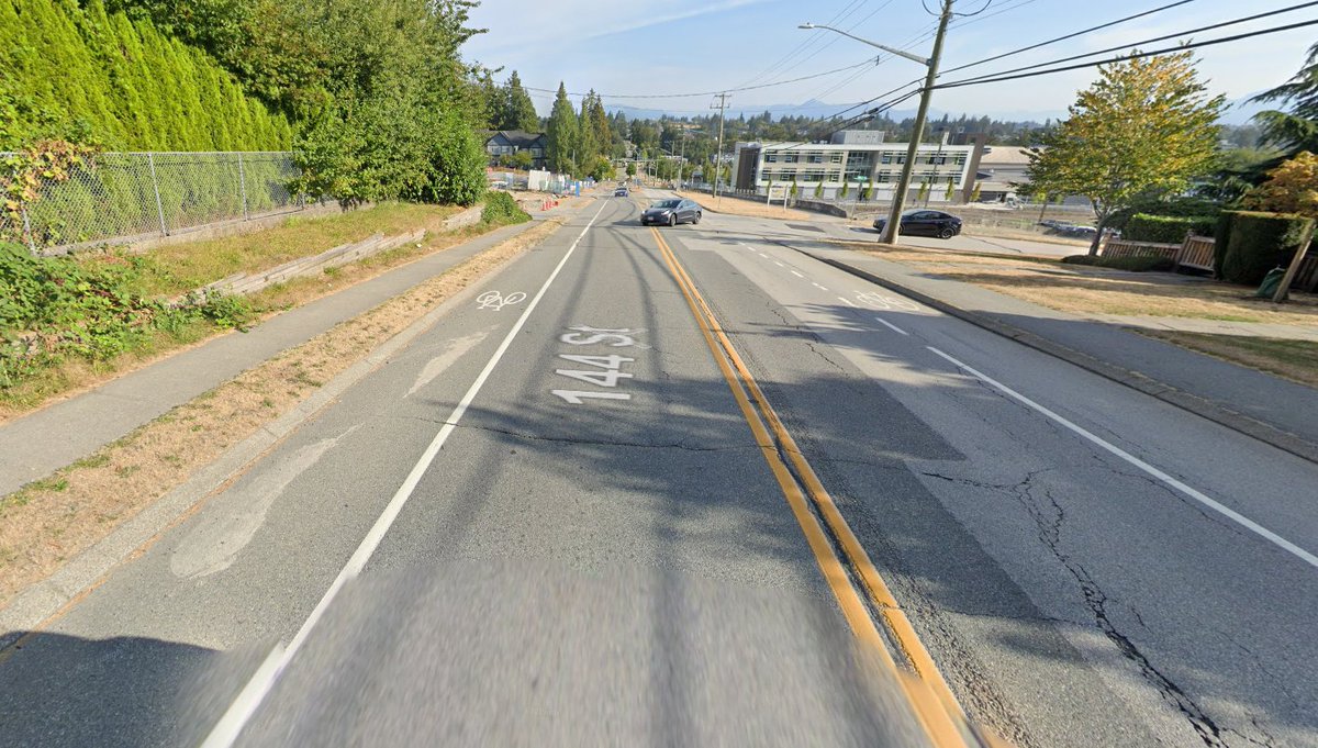 VisionZeroYVR's tweet photo. Surrey has a huge pedestrian fatality problem and now another young person has lost their life. Awful street design. Drivers speed down this hill all the time. Those painted bike "lanes" could be hardened with concrete, making the road narrower. (1/2)

https://t.co/CSQp6iaIJT https://t.co/M58ZWQQLs9
