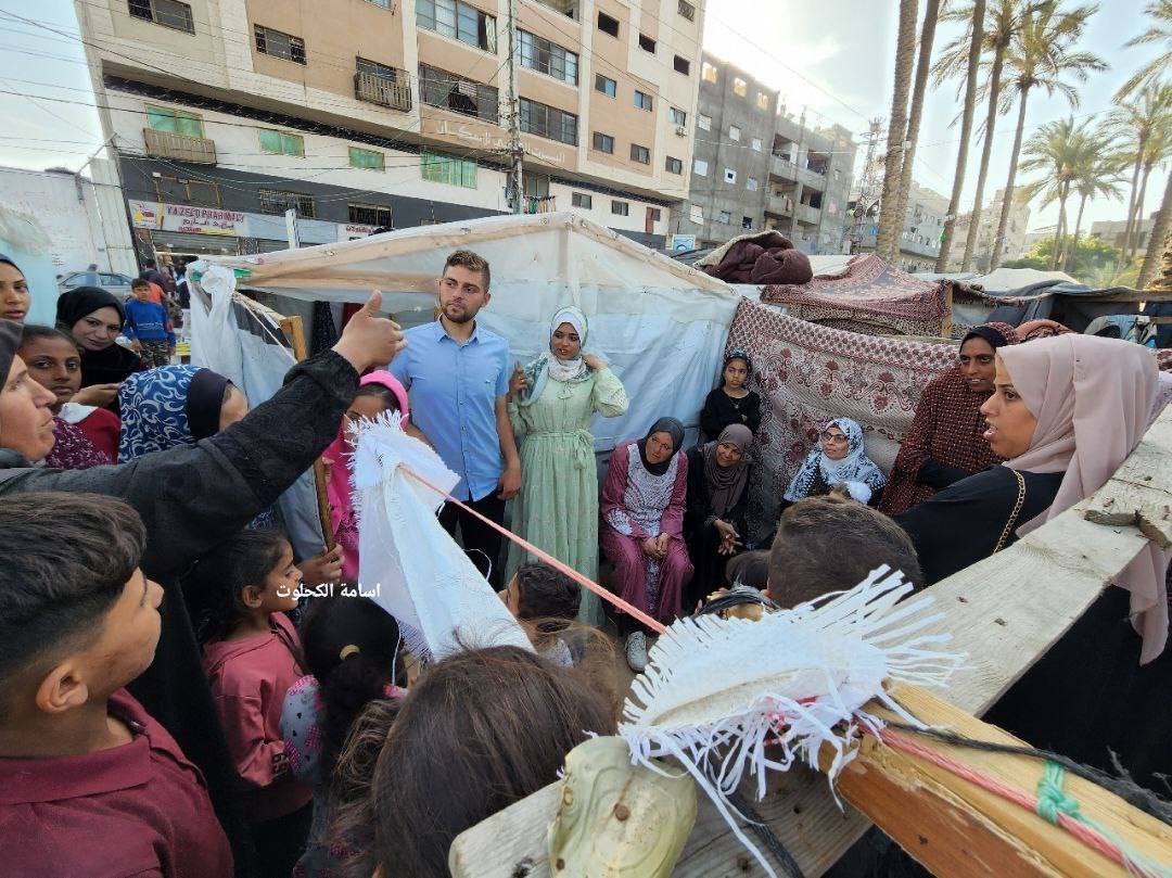 A displaced bride and groom celebrate their marriage in front of a gathering of tents for displaced Palestinian families in Deir el-Balah, in the central Gaza Strip.