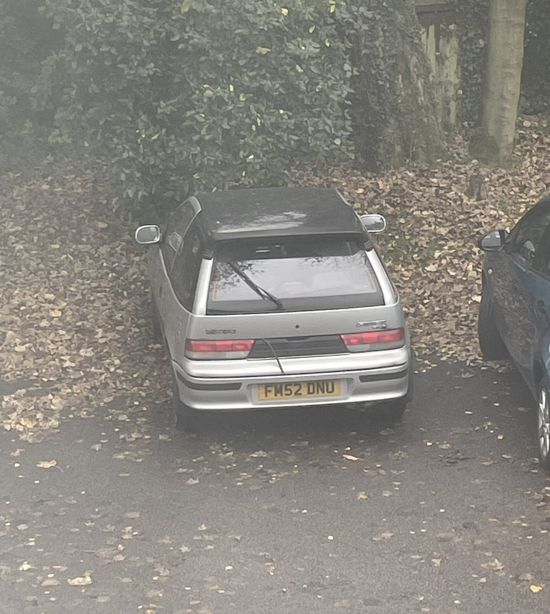 One for #choddytuesday - and this one definitely is #chod - a @suzukicarsuk #swift #suzukiswift from September 2002, still going strong and on 66k at last MOT (summer 2023), complete with trim hanging off and a rear wiper stuck in the up position!

#chodcar #choddycar #retrocar