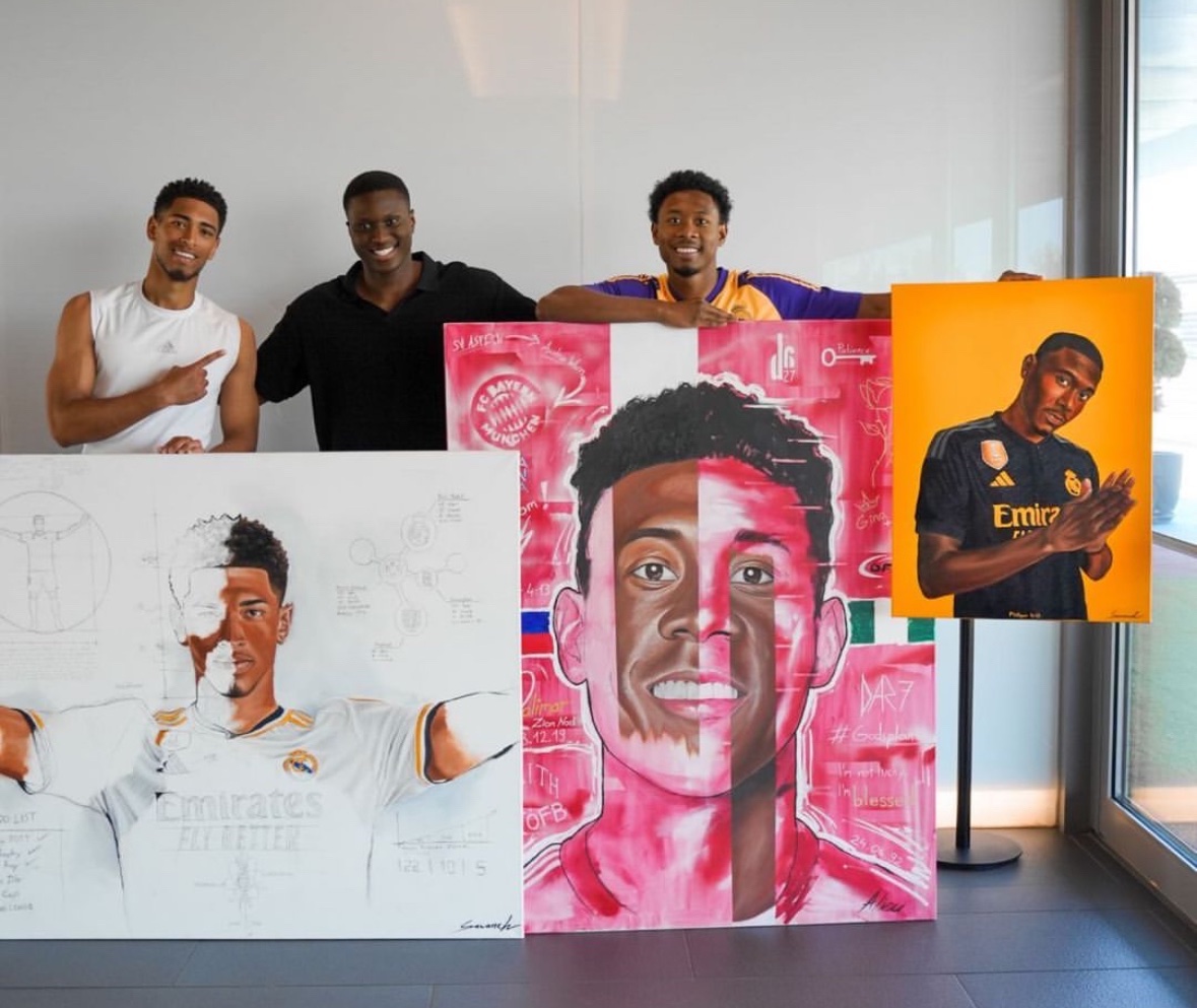 Jude Bellingham and David Alaba with German artist Alieu who gifted them paintings at Valdebebas yesterday 🖼️ #HalaMadrid