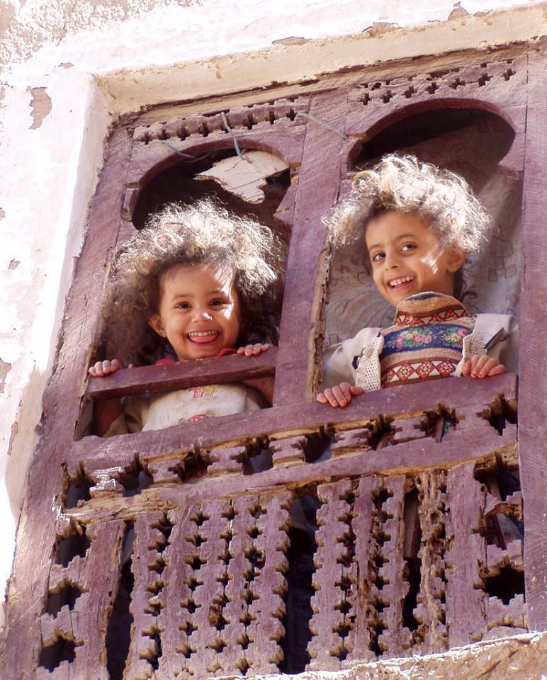 Smiling Yemeni girls from the window, Hadhramaut, Yemen. 📷: Twiga Swala