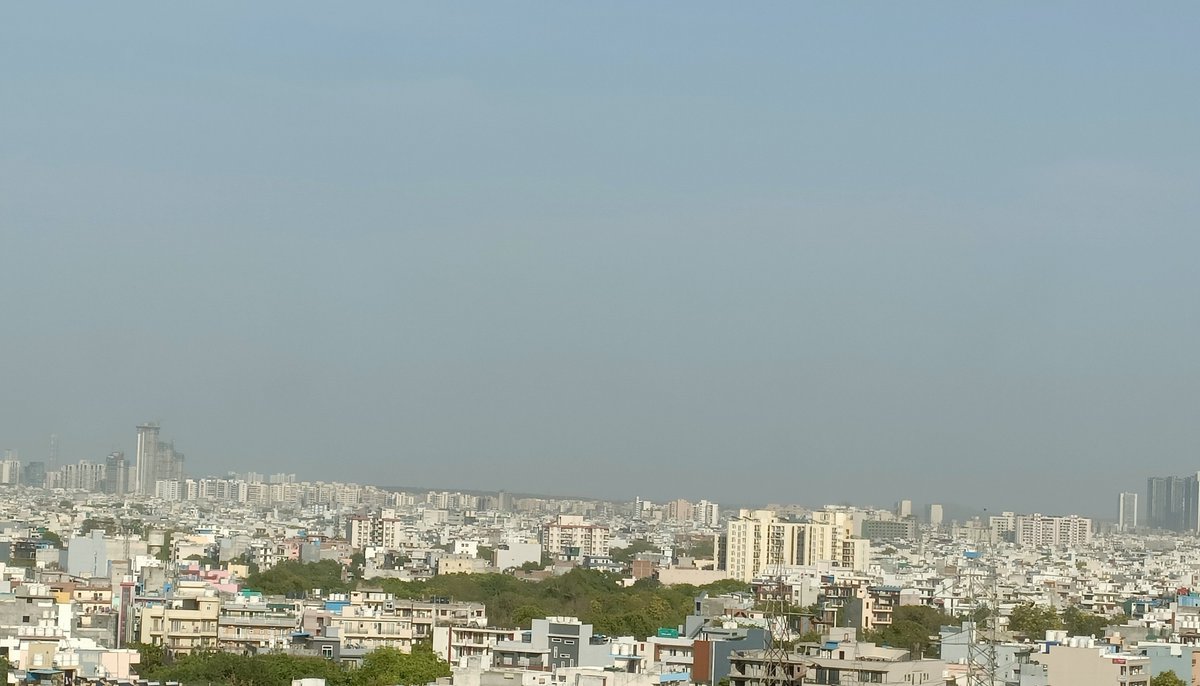 A general view of 'new' Gurgaon as seen from one of the towers near my neighborhood (Sector 40, 39, Sohna Road etc.) with the Aravali hills far in the background. 
The hills can be seen quite clearly from the towers & rooftops after it rains.