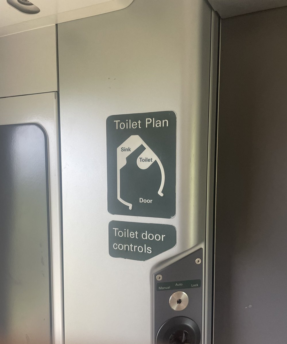 Why is there a map of the train toilet on the wall outside it?