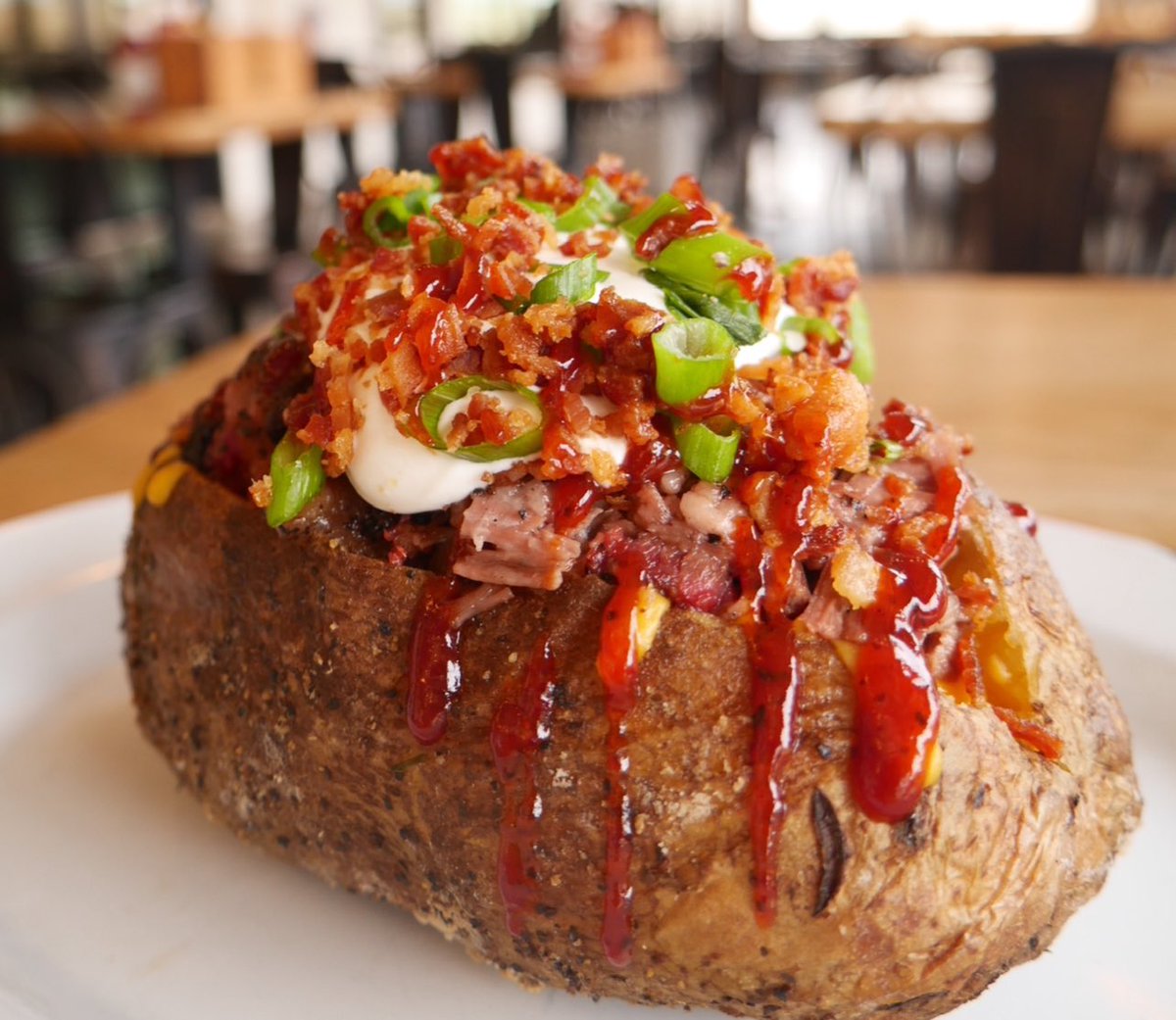🥔 THE CHOPPED BRISKET LOADED BAKED POTATO - 🔥 Giant Potato stuffed with Table Chopped Brisket, Butter, Sour Cream, Cheddar, Bacon, & Green Onion. Drizzled with house bbq sauce. Leading the pack this #Tuesday on the Daily Specials board. #StilesSwitchBBQ . #TexasBBQ #BBQ #ATX