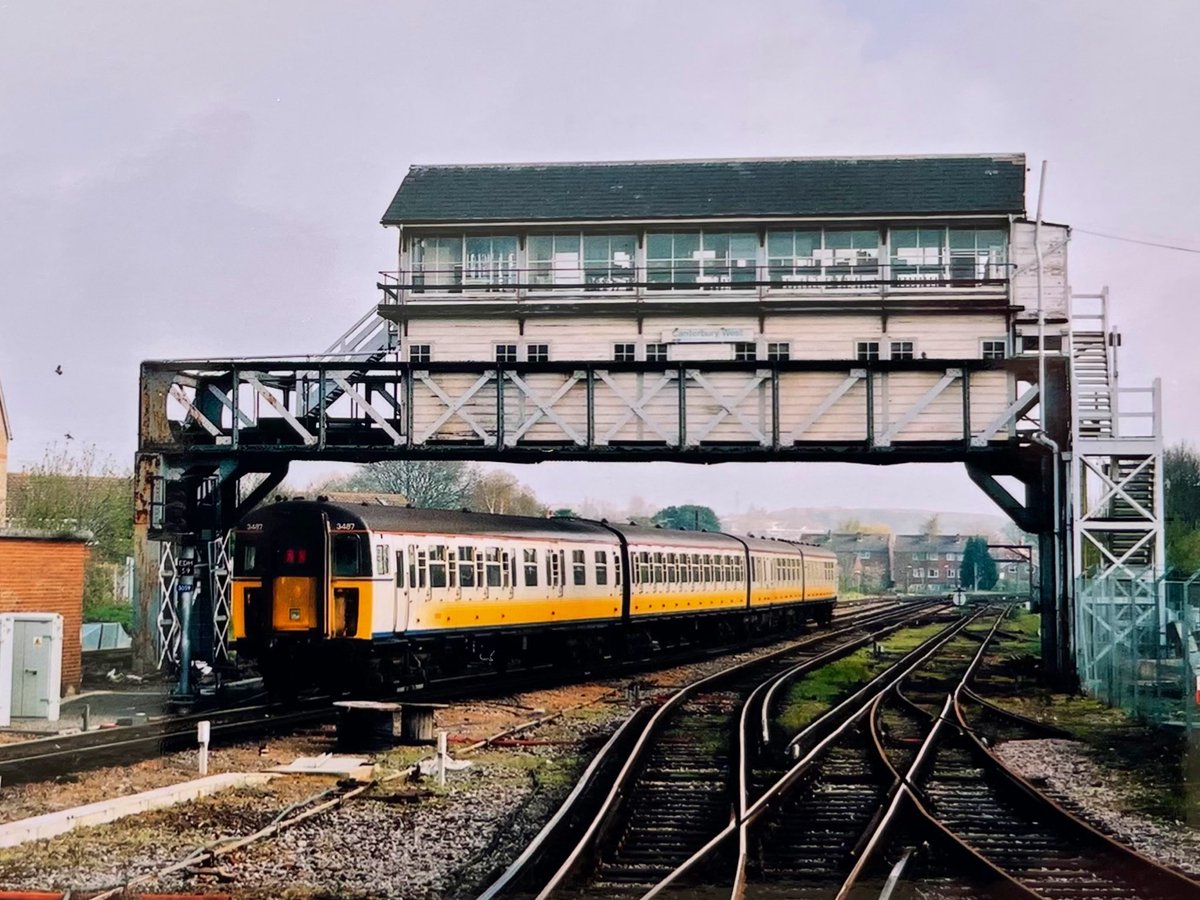 A former #BritishRail 🇬🇧 #4VEP class 423 “slam door” unit, numbered 3487, is seen here passing under #Canterbury West signal box, most likely working a #Southeastern service from #London Charing Cross to #Ramsgate. 
Picture taken in or around 2004. 
#PastTrainTrips