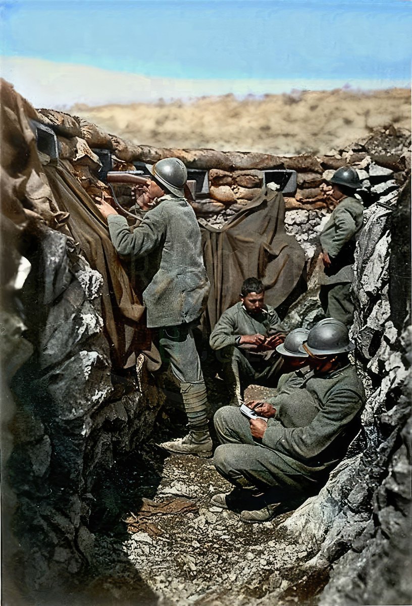 The daily life of Italian soldiers in a trench on the Karst plateau: a sentry armed with a Vetterli rifle watches while the others doze and write letters. WWI.