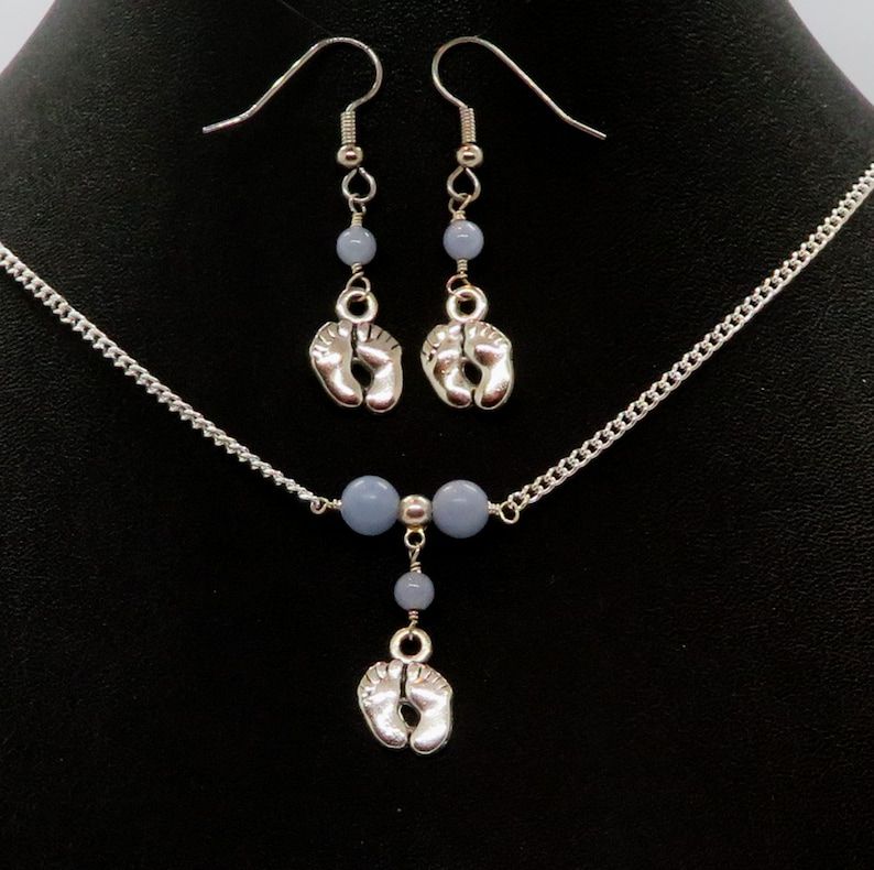 Pamper yourself with the delicate Dainty Baby Feet and Angelite Minimalist Bar Necklace & Earrings Set by RivendellRocksSedona. Handmade in the USA, this small business jewelry is perfect for a touch of elegance. #HandmadeJewelry #MinimalistStyle 🌿 buff.ly/3QNE7U4