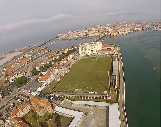 Il bello del calcio è lo stadio 'Aldo e Dino Ballarin' di Chioggia che vedete qui in foto : costruito incredibilmente sull'acqua nel 1931, è intitolato ai due ex- calciatori della Clodiense poi passati al Grande Torino e morti a Superga.