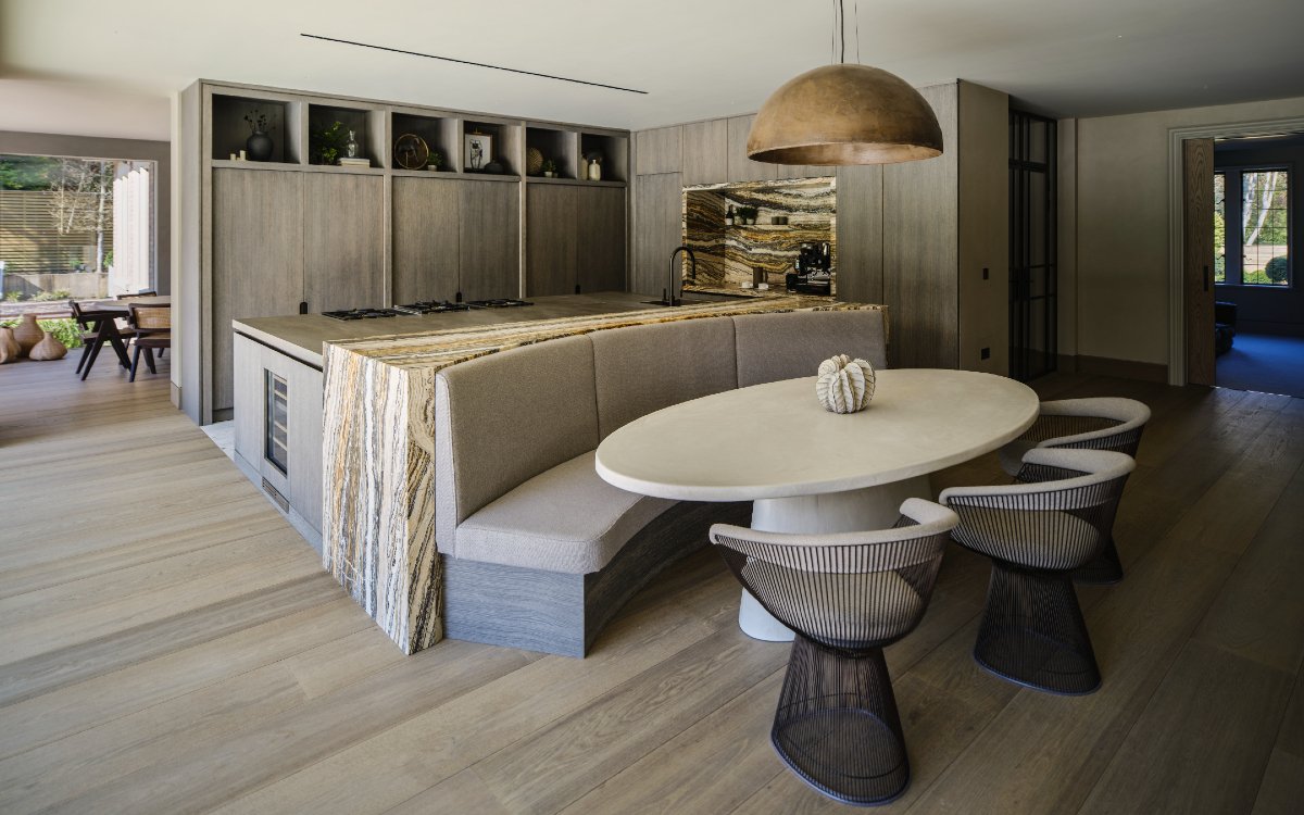 No mistaking the Belgian minimalist inspiration behind this kitchen dining space designed w Keates Interiors. Fumed oak flat fronts to the cabinets were stained in a mid-grey to coordinate with the neutral palette of natural materials used throughout the interior of the house.