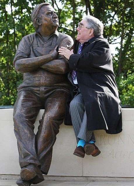 Ronnie Corbett sitting with the statue of his comedy partner Ronnie Barker as Norman Stanley Fletcher, the statue is sitting on a stone bench looking up at the Aylesbury Waterside Theatre where he made his first professional appearance. (by acclaimed sculptor Martin Jennings).