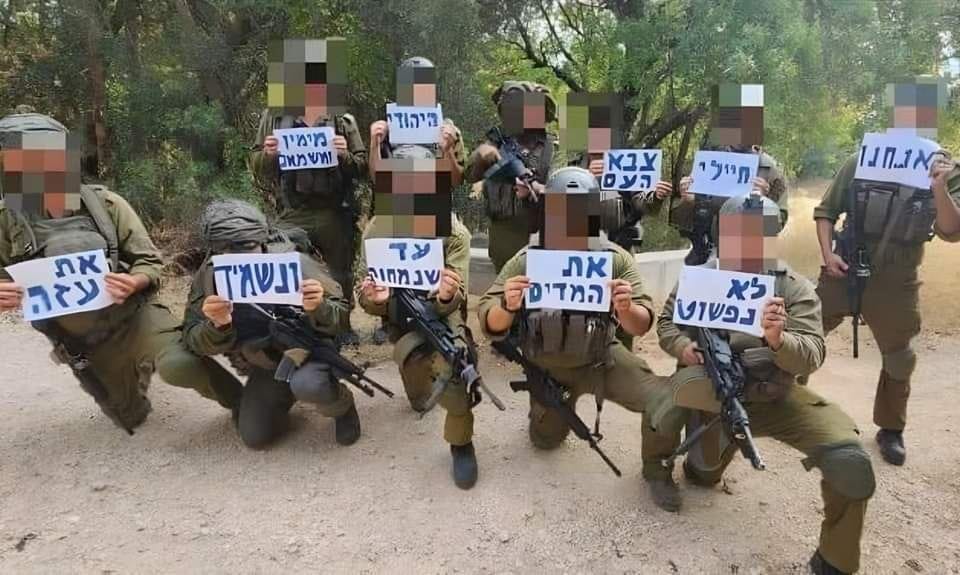 IOF soldiers took a picture with signs that say: 'we [are] soldiers of the Jewish people, from the right and from the left, will not take down the uniform until we wipe out and destroy Gaza'