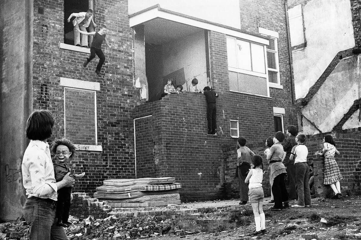 Kids jumping onto mattresses by Tish Murtha. From the series Youth Unemployment (1981). Photo © Ella Murtha, all rights reserved.