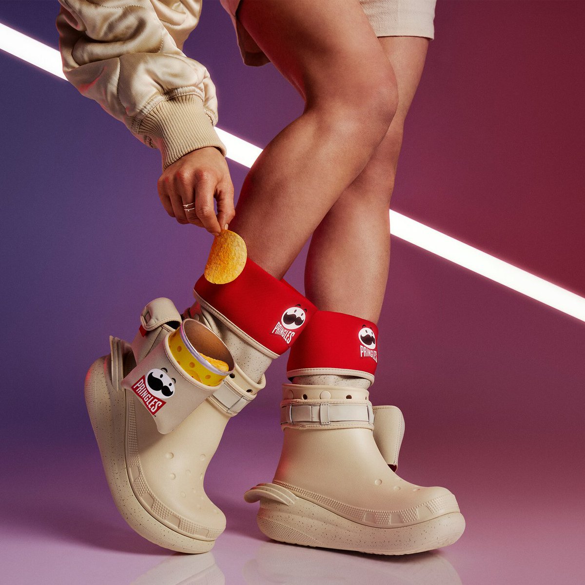 MorningBrew's tweet photo. Crocs just cooked up another insane collab—this time with Pringles 

• Classic Clog ($70)
• Classic Slide ($70)
• Boot w/Pringles holster ($100)

They also created an exclusive new Pringles flavor, available to anyone who makes a purchase from the collection https://t.co/jDAOl7Rd8z