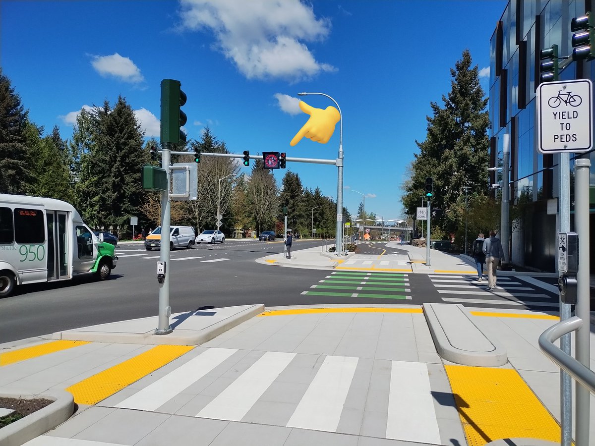 Two-way cycletrack on 156th Ave NE in Redmond. Includes a protected right turn phase separating people on bikes from drivers entering a major parking garage.