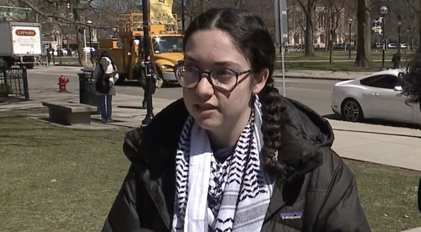 Update: the woman with the megaphone has been identified as University of Michigan sophomore Annabelle Bean.