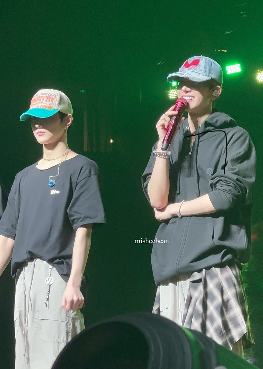 heeseung and jungwon wearing a cap on stage omg