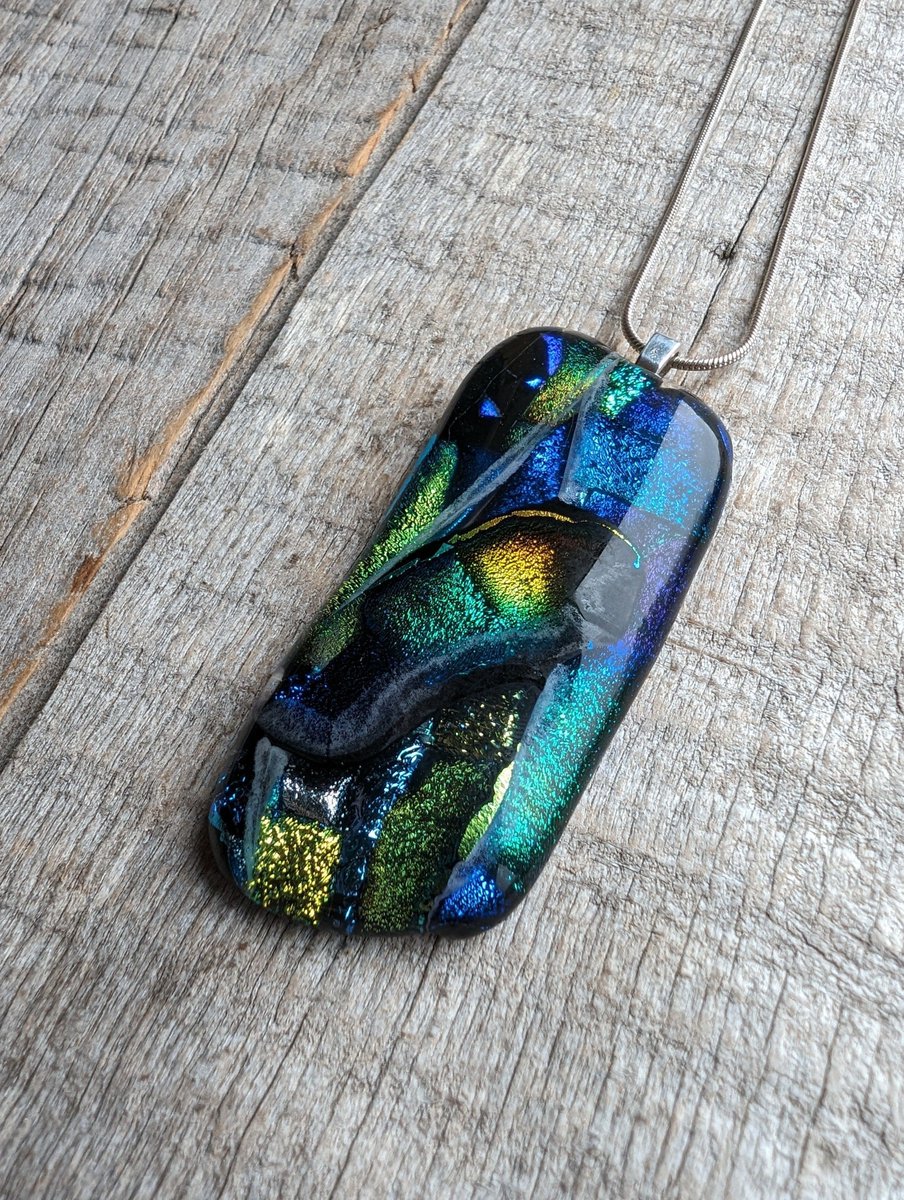 A unique new organic and natural shaped dichroic glass necklace. Lovely large layered glass pendant made from handcut sparkling dichroic glass. #earlybiz #handmade #etsy #shopindie #etsyuk #giftideas buff.ly/49JzT7m