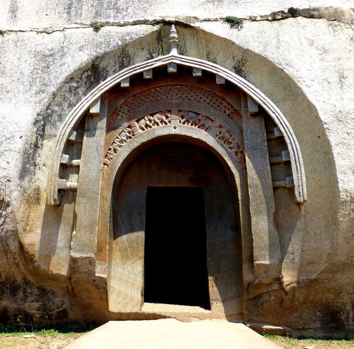 This sacred rock-cut cave temple in India, believed to have been carved out around the 3rd century BCE, is known for its unique architectural features and association with ancient ascetic practices. -The Mauryan carved door of Lomas Rishi, one of the Barabar Caves, c. 250 BCE.